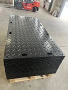 Black metal platform on a pallet with a forklift in the background