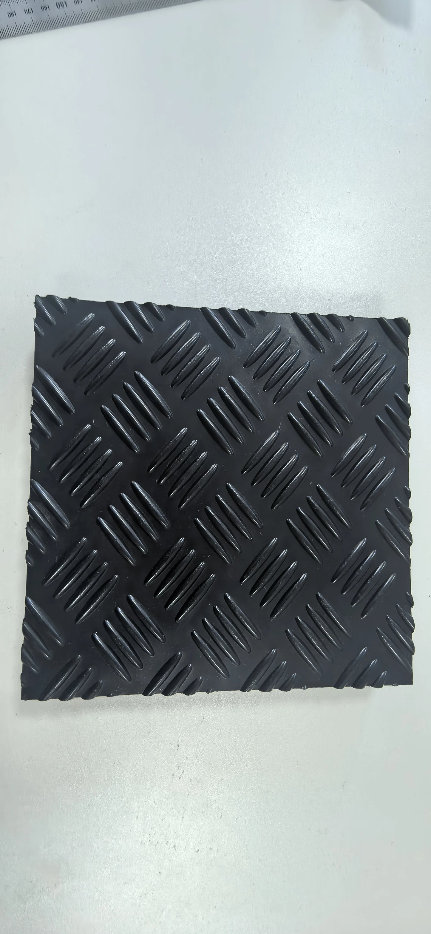 Black textured square mat on a white background
