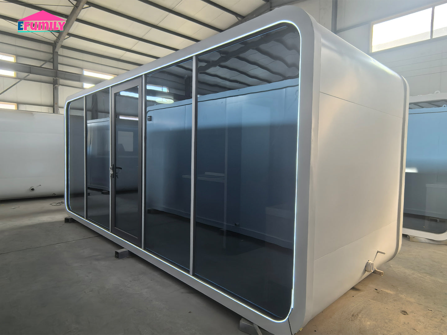 Modular office pod with glass walls in a warehouse setting