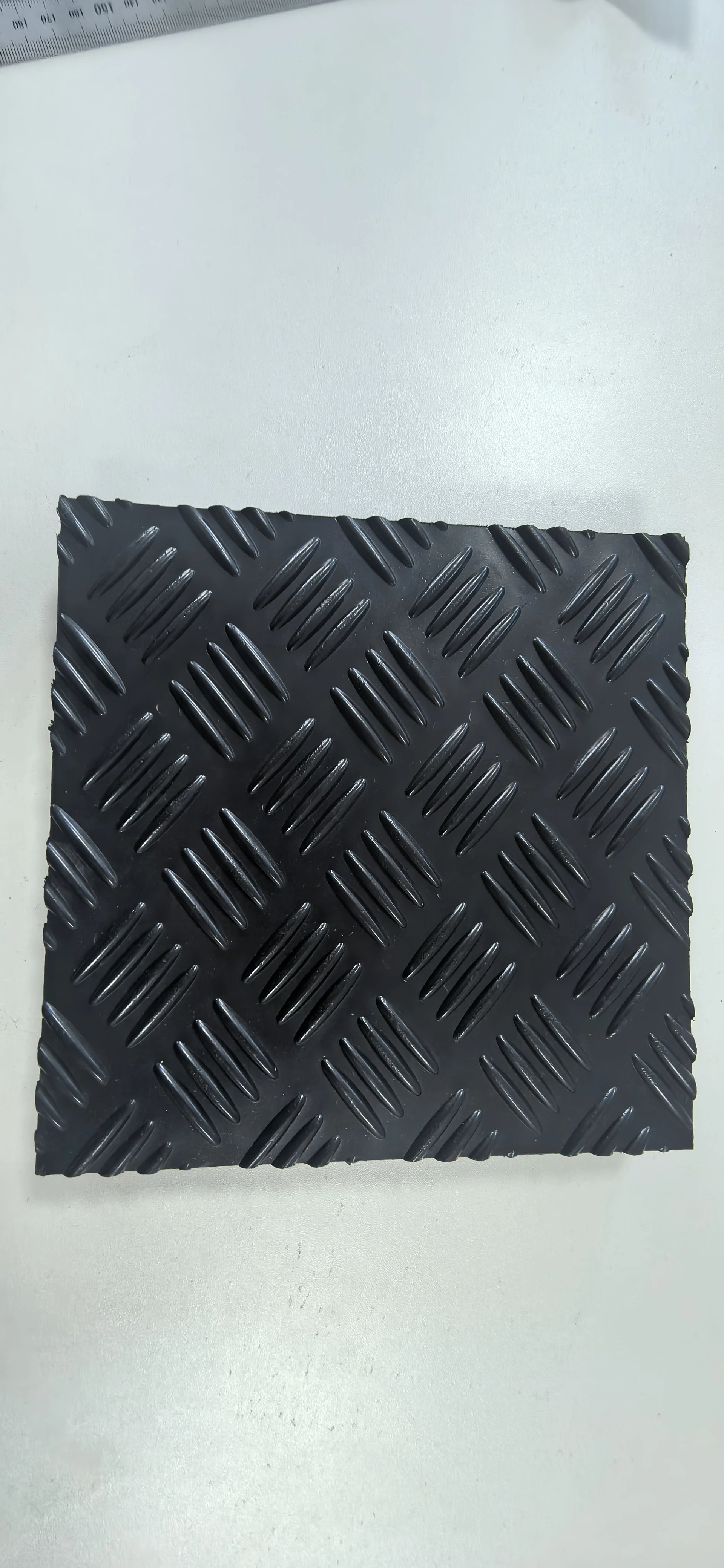 Black textured square mat on a white background