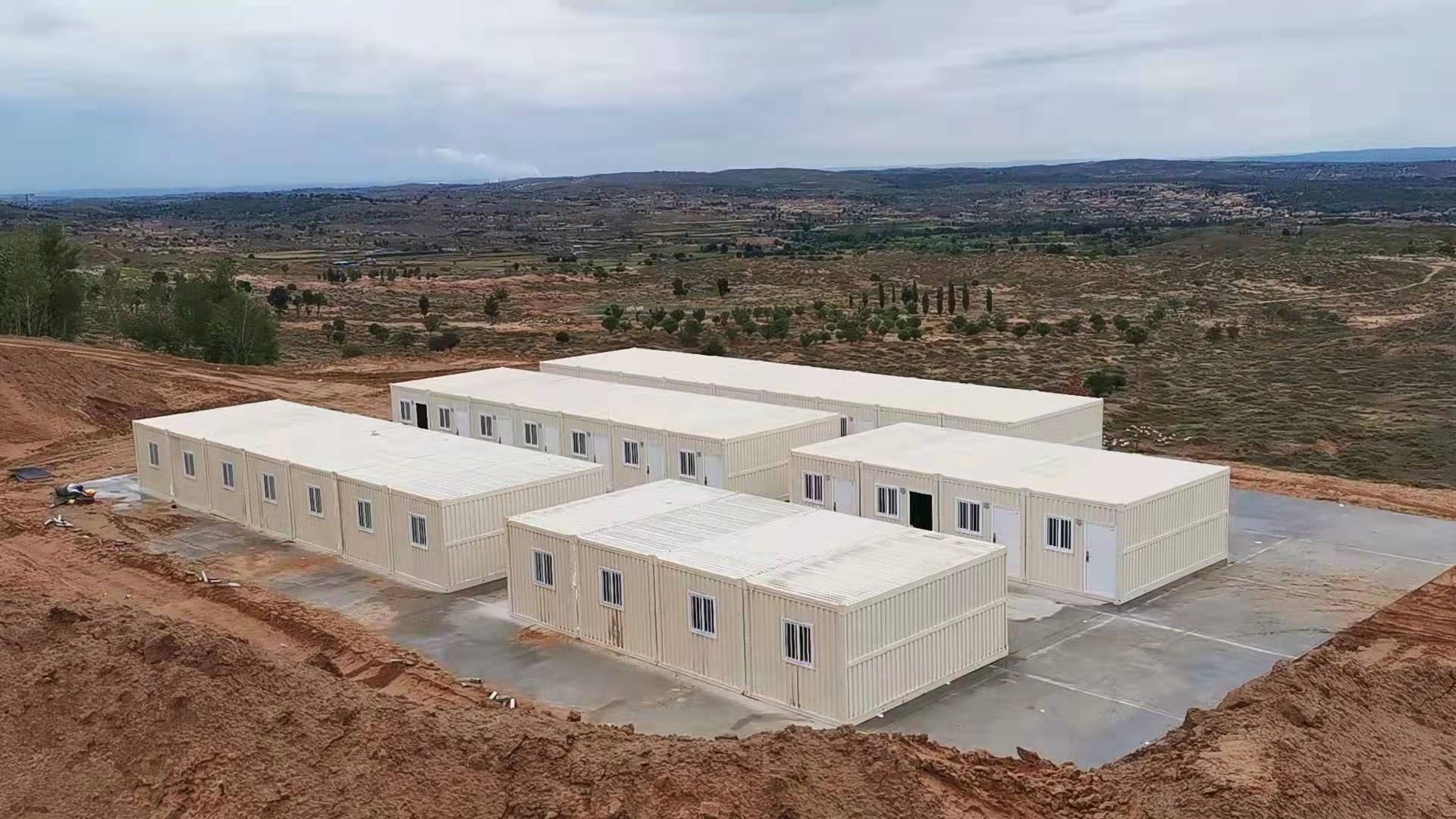 Modular building structures on a construction site with a landscape in the background