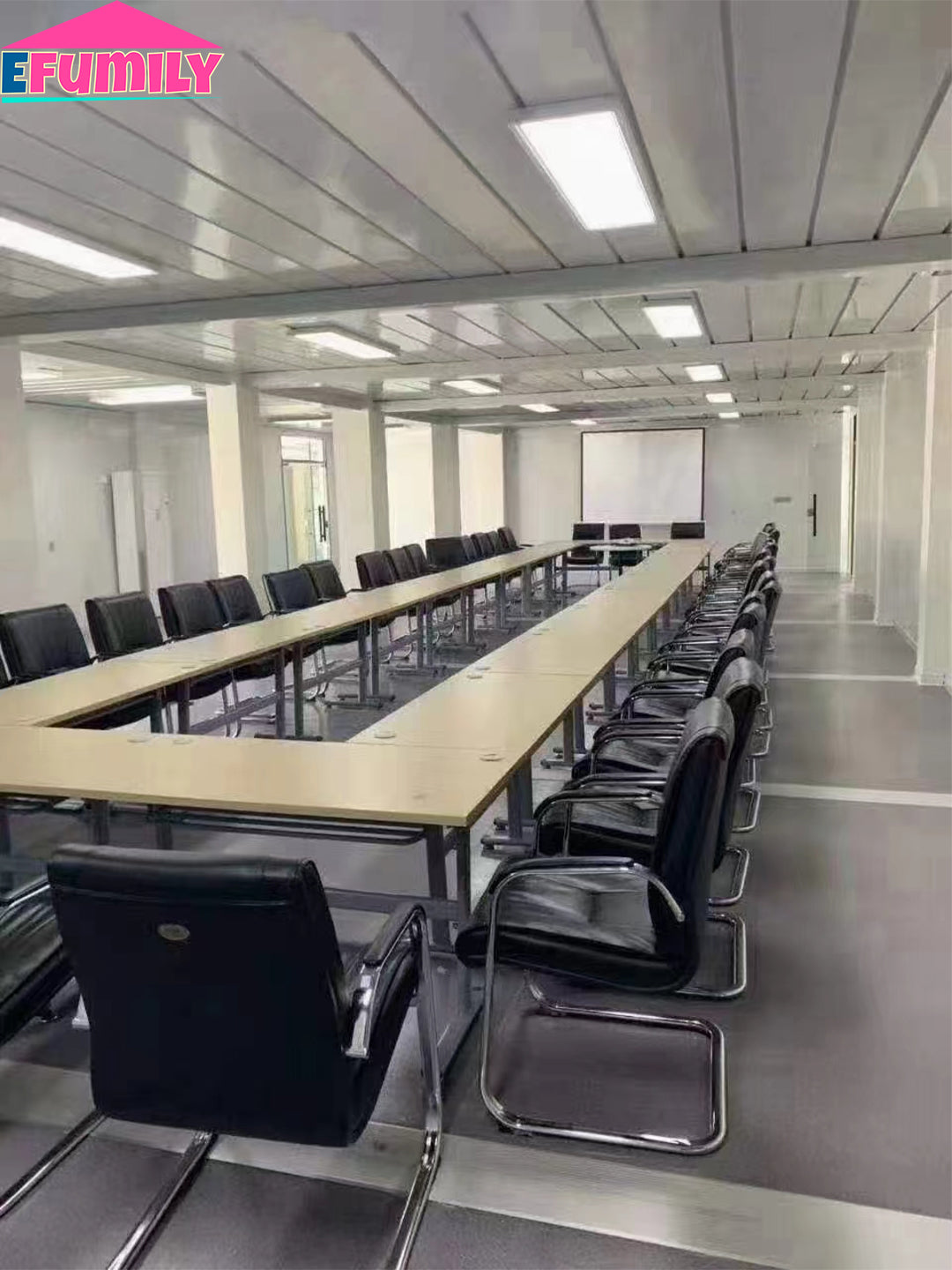 Conference room with long U-shaped table and chairs, featuring the EFAMILY logo.